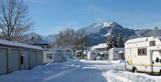 wintercamping, wohnmobil im schnee auf campingplatz