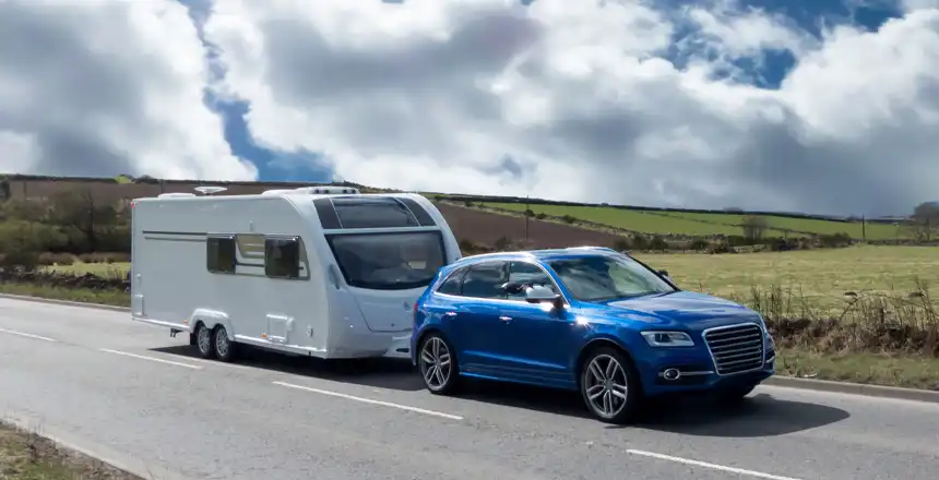 caravan-blaues-auto Blaues Auto mit Wohnanhänger