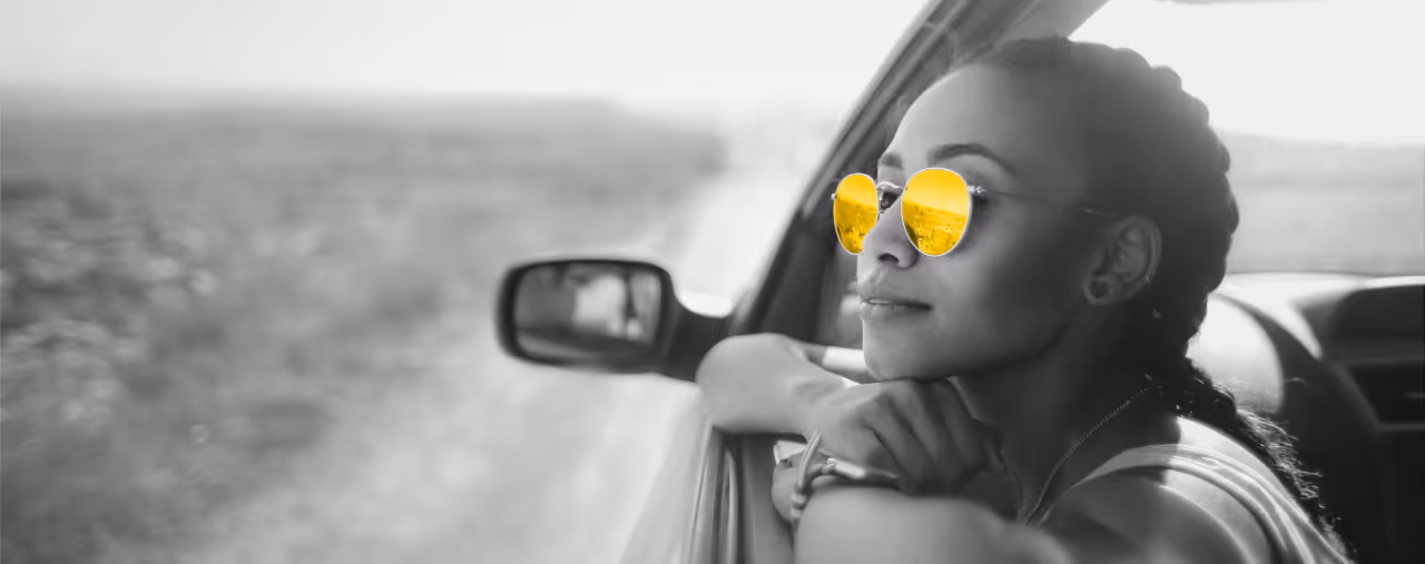 frau mit gelber sonnenbrille lehnt aus auto seitenfenster, hertz autovermietung